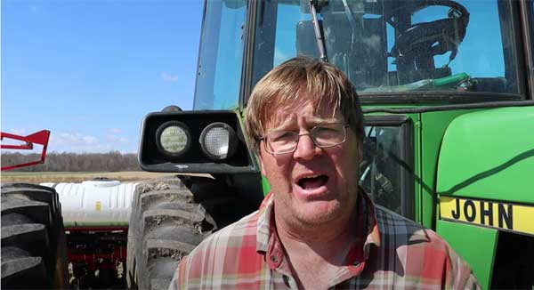 Man talking in front of tractor