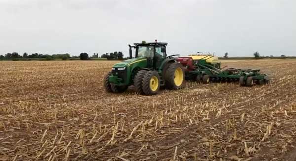 Tractor in harvested corn field