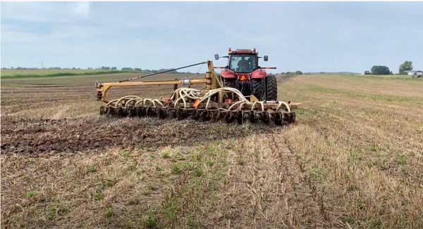 Tractor applying manure to farm field