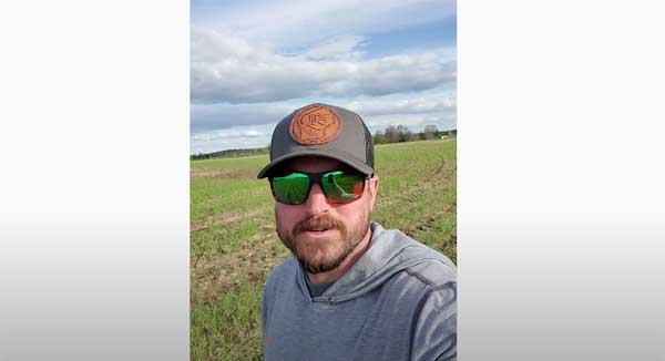 Man in farm field looking into camera