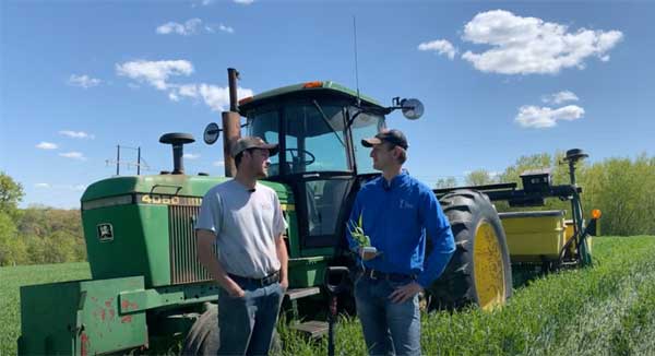 Two men talking in front of tractor