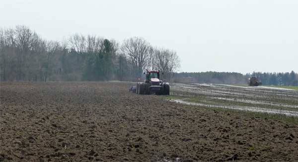 Tractor in farm field spreading manure