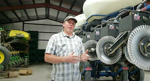 Farmer standing in front of farm equipment in a barn