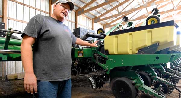 Farmer pointing to no-till planter