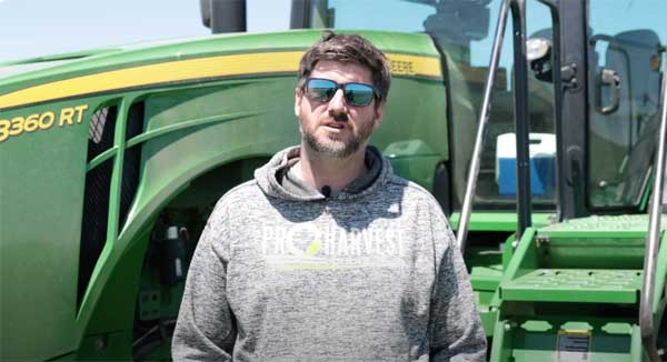 Male farmer speaking to the camera with a tractor behind him