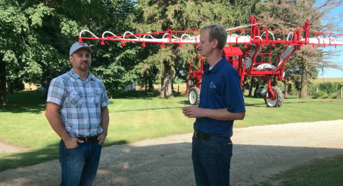 Two men standing in front of an interseeder