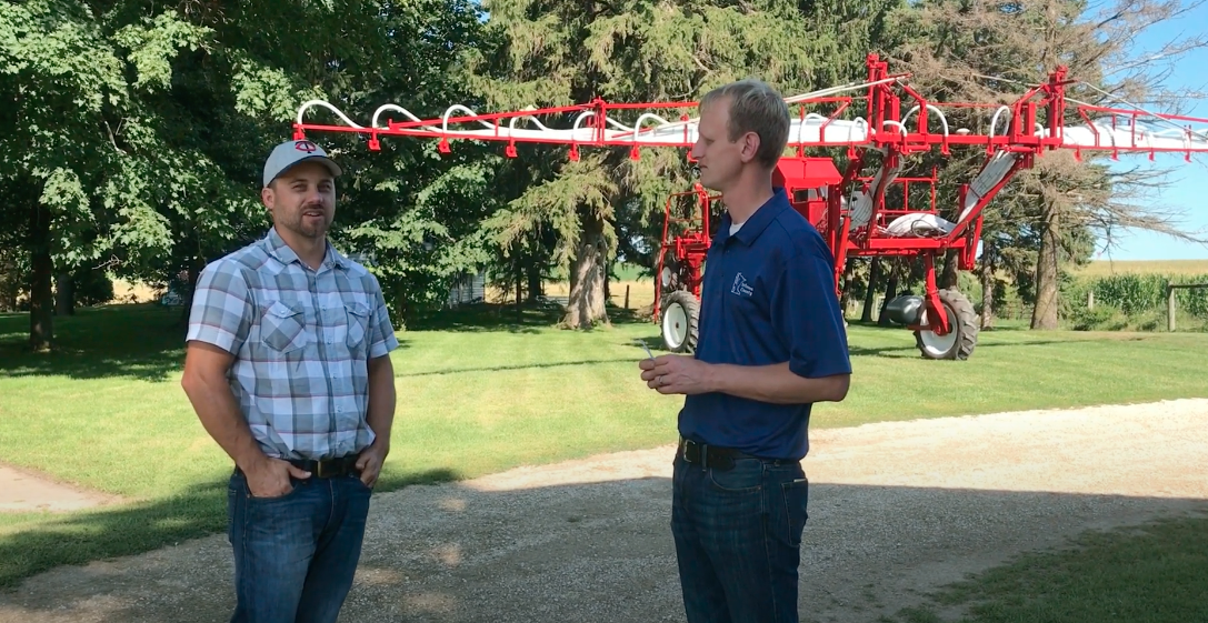 Two men standing in front of an interseeder
