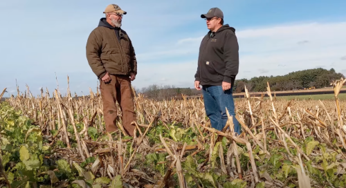 Two men talking in a farm field