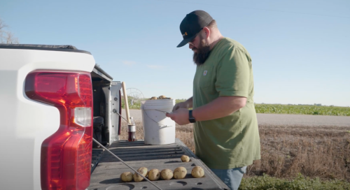 Man testing soil samples in a truck bed