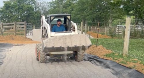 Man driving bulldozer to make feed pad